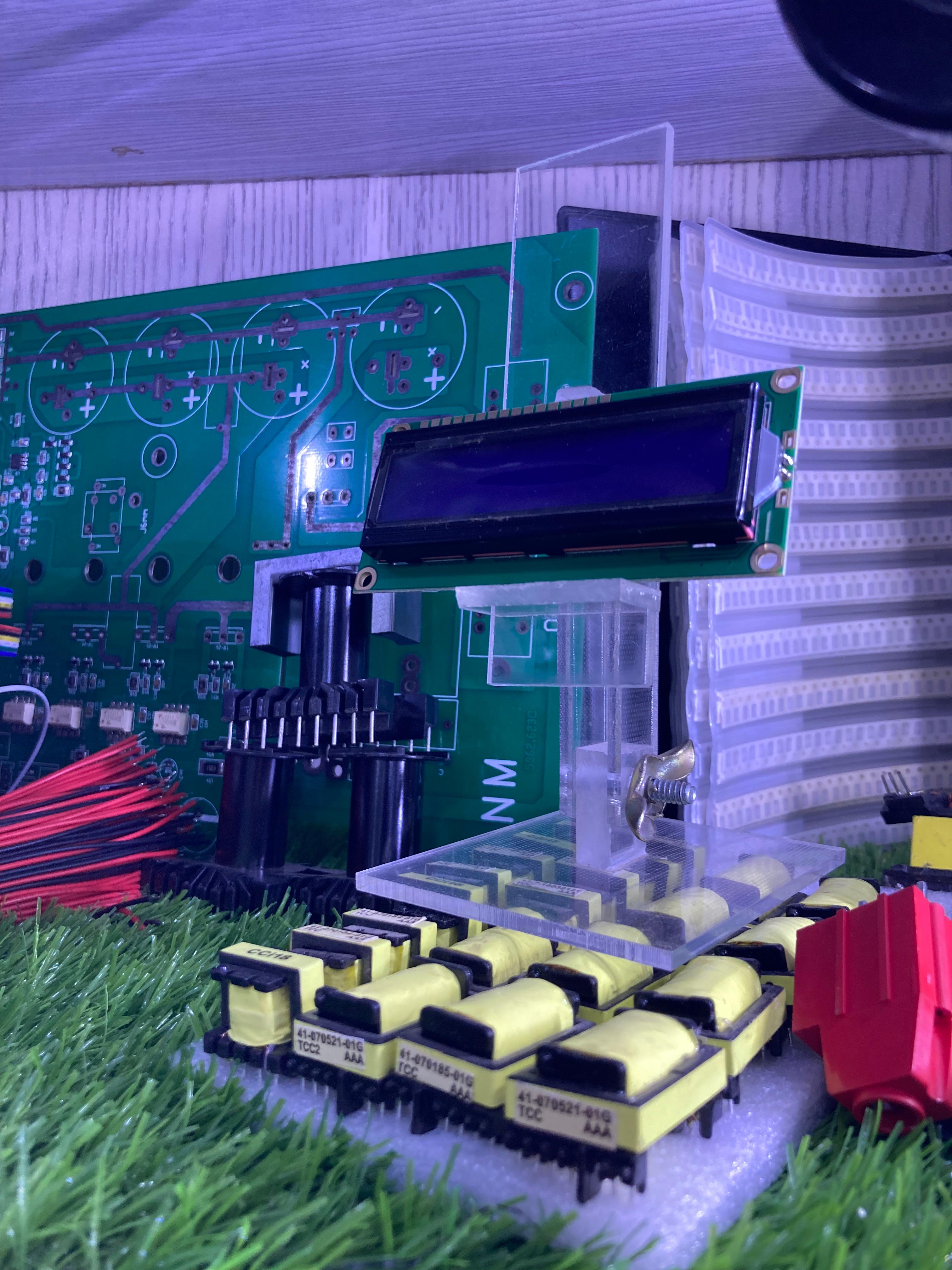 16x2 Blue LCD module connected to a green PCB board on artificial grass background