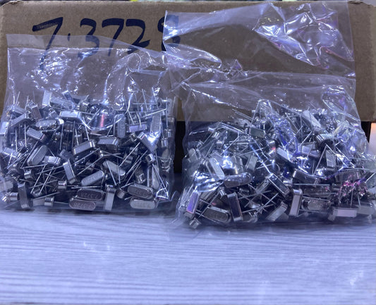 The Component Centre 7.3728 quartz crystal oscillator components in clear plastic bags on a table