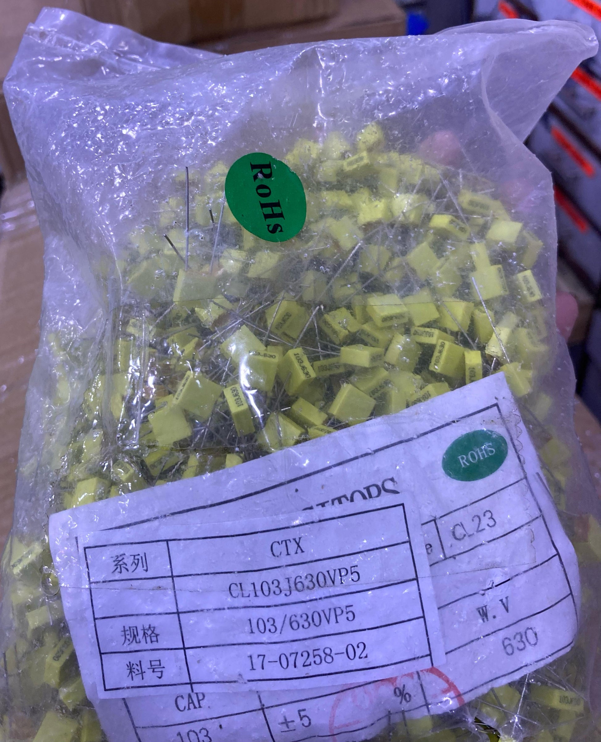 Bag of yellow 104J100 0.1uF capacitors with leads from The Component Centre