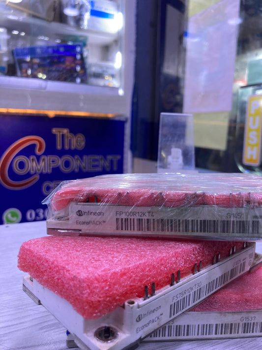 Infineon FP100R12KT4 power module with pink protective foam on white surface at The Component Centre