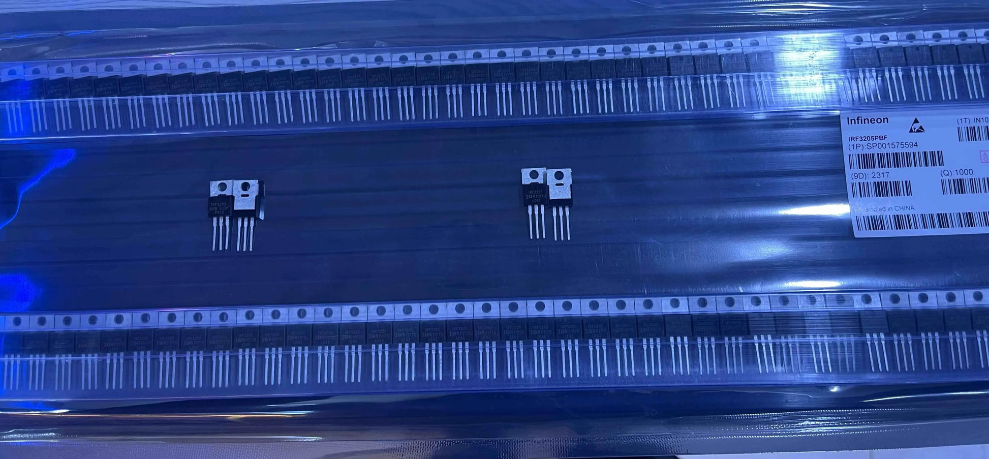 IRF3205 power MOSFET transistors displayed on black tape packaging from The Component Centre