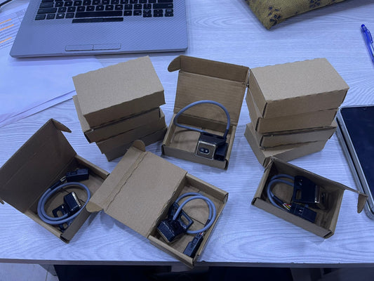 Leno sensor Toyota 710 units packed in small cardboard boxes on a desk with laptop and tablet nearby