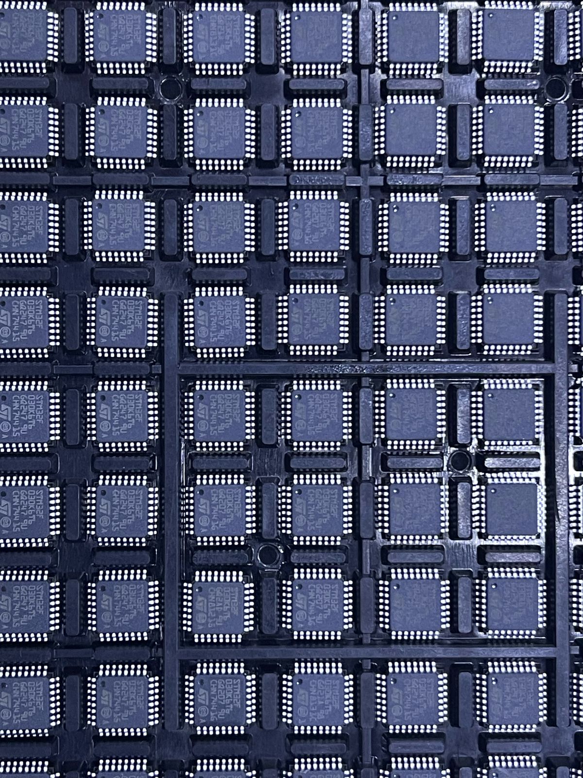 Multiple STM32F030K6T6 microcontroller chips from The Component Centre in a black tray
