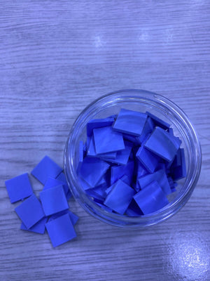 Jar of blue square Pre-Cut Thermal Silicone Pads in a clear jar on wood surface for electronics cooling