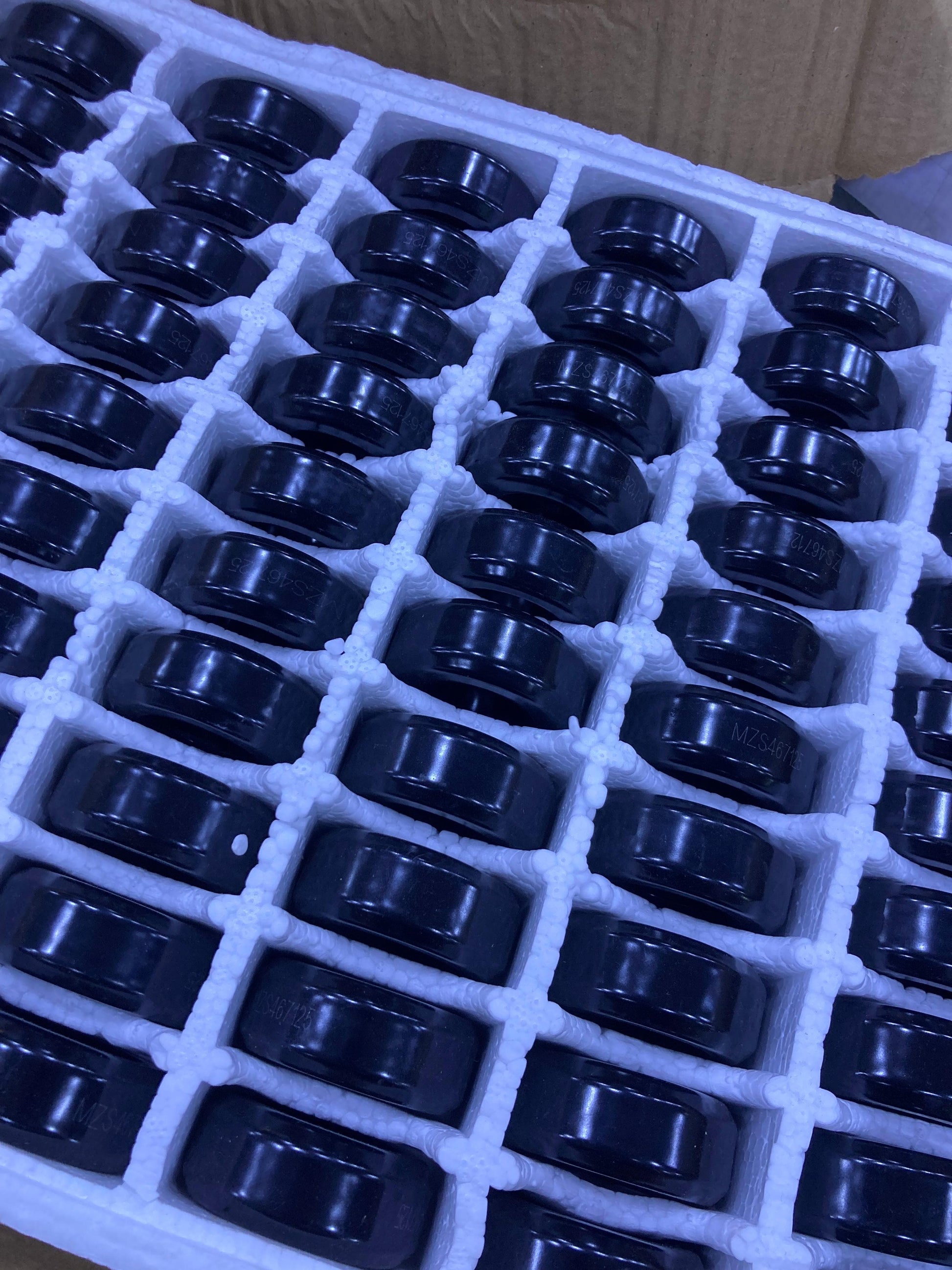 Multiple black 2 Inch Ferrite Core components neatly arranged in white protective packaging