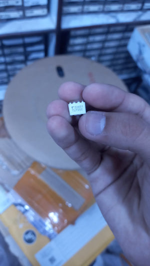 Close-up of hand holding a small electronic component labeled TLP250 from The Component Centre