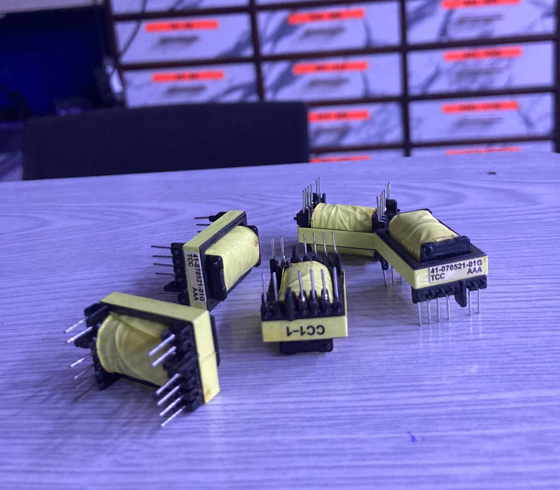 Electronic components labeled TX 41-070521-01G from The Component Centre on a wooden surface